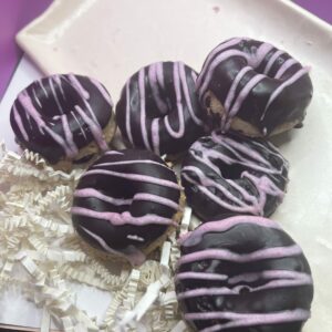 A Box of Assorted Donuts Featuring Vibrant Purple and Pink Icing